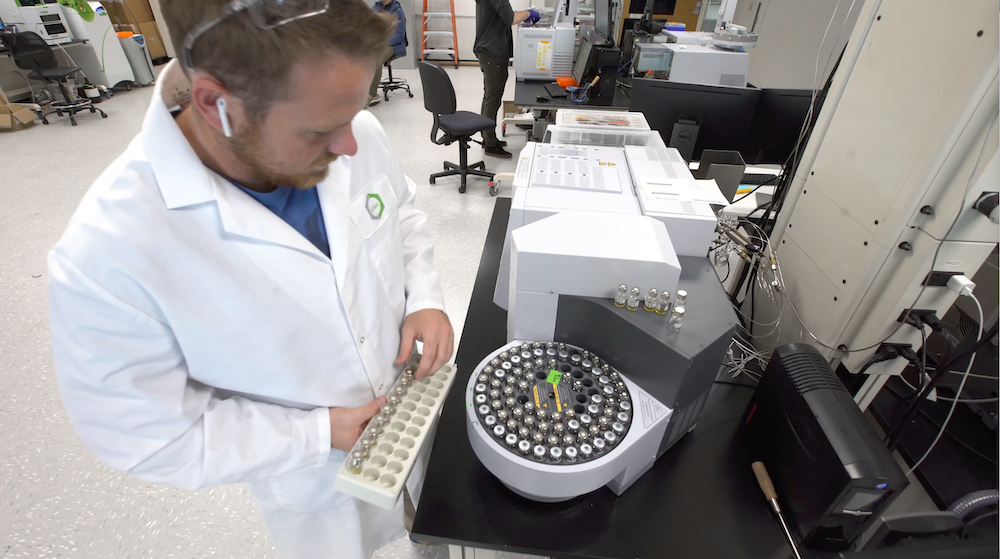 Lab scientist adding test tubes to a centrifuge